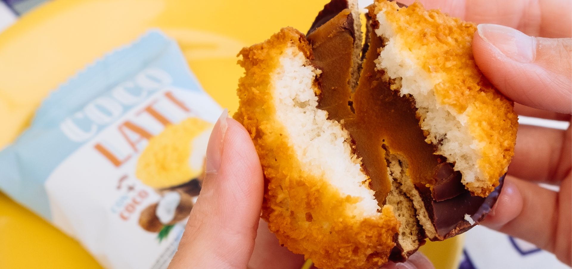Alfajor cocolate partido al medio mostrando el exquisito dulce de leche. De fondo el paquete